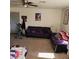 Comfortable living room featuring a purple sofa, carpet flooring, and various decorative items at 561 E Bourbon St, Pahrump, NV 89048