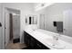 Bathroom features dual sinks, a large mirror, and shower over tub with neutral finishes at 5761 E Badlands Ln, Pahrump, NV 89061