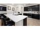 Modern kitchen with black cabinetry, stainless steel appliances, and a large quartz countertop island at 5761 E Badlands Ln, Pahrump, NV 89061