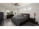 Spacious main bedroom with a ceiling fan, multiple windows, and wood-look flooring at 5761 E Badlands Ln, Pahrump, NV 89061