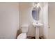 Small bathroom features a pedestal sink and toilet with a round mirror, and minimal decor at 5907 Zawawi Ct, Las Vegas, NV 89110