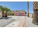 Two-story home with a two-car garage, palm trees, and desert landscaping for an appealing curb presence at 5907 Zawawi Ct, Las Vegas, NV 89110