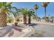 Two-story home with a two-car garage, palm trees, and desert landscaping for an appealing curb presence at 5907 Zawawi Ct, Las Vegas, NV 89110