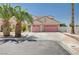 Two-story home with a two-car garage, palm trees, and desert landscaping for an appealing curb presence at 5907 Zawawi Ct, Las Vegas, NV 89110