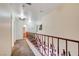 Upstairs hallway features carpet and decorative wrought iron, leading to the bedrooms and bathrooms at 5907 Zawawi Ct, Las Vegas, NV 89110