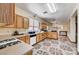 Kitchen features light wood cabinetry, white appliances, neutral countertops, and a view to the living room at 5907 Zawawi Ct, Las Vegas, NV 89110