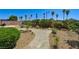 Backyard with desert landscaping, lush green bushes, a rock pathway and a fire pit at 6808 Mystic Plain Ct, Las Vegas, NV 89149