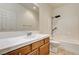 Bright bathroom featuring a tiled countertop, wood cabinets, and a combined shower and bathtub with white tile surround at 6808 Mystic Plain Ct, Las Vegas, NV 89149