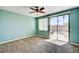 Carpeted bedroom with aqua walls, ceiling fan, and sliding glass doors leading to a patio area at 6808 Mystic Plain Ct, Las Vegas, NV 89149