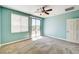 A light and airy bedroom with aqua walls, ceiling fan, and slider leading to a garden at 6808 Mystic Plain Ct, Las Vegas, NV 89149