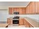 Kitchen showcases stainless steel appliances, wood cabinets, and a tile backsplash at 6808 Mystic Plain Ct, Las Vegas, NV 89149