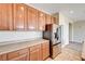 Well-equipped kitchen with stainless steel refrigerator and wooden cabinets at 6808 Mystic Plain Ct, Las Vegas, NV 89149