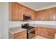 Functional kitchen with wooden cabinets, stainless steel appliances, and tile flooring at 6808 Mystic Plain Ct, Las Vegas, NV 89149