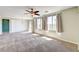 Bright living room with carpet flooring, ceiling fan, and large windows at 6808 Mystic Plain Ct, Las Vegas, NV 89149