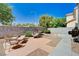 A cozy backyard patio setup with stylish wicker furniture and a charming lounge area on textured tile at 7813 Falconwing Ave, Las Vegas, NV 89131