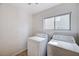 Functional laundry room equipped with a washer, dryer, and a window for natural light at 7813 Falconwing Ave, Las Vegas, NV 89131
