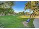 Park featuring a vast green lawn, bench, shade trees and walking path under a blue sky at 8928 Stafford Springs Dr, Las Vegas, NV 89134