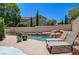 Backyard pool with a waterfall feature and poolside lounge chairs, surrounded by lush landscaping at 8928 Stafford Springs Dr, Las Vegas, NV 89134