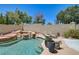 Backyard oasis featuring a rock waterfall, a sparkling pool, and lounge chairs with private landscaping at 8928 Stafford Springs Dr, Las Vegas, NV 89134