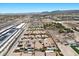 A high aerial shot of a desert community with solar panels and pool with mountain views and a highway at 9233 Onyx Point Ct, Henderson, NV 89074