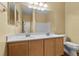 Well-lit bathroom featuring a double sink vanity with white countertops and wood cabinets at 9233 Onyx Point Ct, Henderson, NV 89074