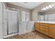 Bathroom with walk-in tub, glass shower, dual sink vanity, large mirror, and neutral color palette at 9233 Onyx Point Ct, Henderson, NV 89074