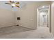 Spacious carpeted bedroom with ceiling fan and an arched entryway at 9233 Onyx Point Ct, Henderson, NV 89074