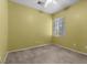 Neutral bedroom featuring tan carpeting, cream walls, ceiling fan, and window providing natural light at 9233 Onyx Point Ct, Henderson, NV 89074
