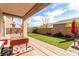 Inviting backyard with artificial grass, stone patio, seating area, and mature landscaping at , Las Vegas, NV 89166