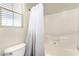 Bright bathroom with a white shower curtain and tub with tiled walls and a window at , Las Vegas, NV 89166