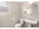 Convenient half bathroom featuring a pedestal sink, toilet, and window at , Las Vegas, NV 89166