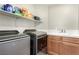 Laundry room with modern washer and dryer units, and a sink with wooden cabinets at , Las Vegas, NV 89166