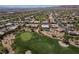 An aerial view showcasing a golf course, desert landscape, and custom homes in the community at 10240 Notte Ave, Las Vegas, NV 89135