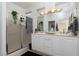 Bright bathroom with a large mirror, double sinks, and a glass-enclosed shower at 10240 Notte Ave, Las Vegas, NV 89135