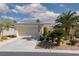 Charming single-story home featuring a two-car garage, desert landscaping and mature palm trees at 10240 Notte Ave, Las Vegas, NV 89135