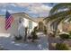Inviting front entrance with desert landscaping, an American flag, and shuttered windows at 10240 Notte Ave, Las Vegas, NV 89135