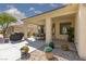 View of a covered patio with dining set, manicured landscaping, and convenient access to the yard at 10240 Notte Ave, Las Vegas, NV 89135