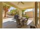 Covered patio with outdoor dining set, ceiling fan, and views of the landscaped backyard at 10240 Notte Ave, Las Vegas, NV 89135