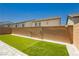Clean backyard space with artificial turf, brick walls, and stone patio pavers; perfect for relaxation at 10429 Rose Palisade St, Las Vegas, NV 89141