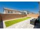 Compact backyard featuring artificial turf, brick walls, and patio pavers under a clear blue sky at 10429 Rose Palisade St, Las Vegas, NV 89141