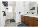 Bright bathroom features a double sink vanity, walk-in shower, and neutral-toned tile floors at 10429 Rose Palisade St, Las Vegas, NV 89141