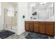 Spacious bathroom boasts double sinks, wood cabinets, a large mirror, and a walk-in shower at 10429 Rose Palisade St, Las Vegas, NV 89141