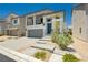 Charming two-story home featuring a balcony, gray-tone stucco, a paver driveway, and minimalist desert landscaping at 10429 Rose Palisade St, Las Vegas, NV 89141