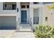 Close-up of the front entrance showcasing a blue door, pavers, desert plants, and minimalist landscaping at 10429 Rose Palisade St, Las Vegas, NV 89141