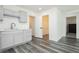 Kitchenette area with gray cabinets, sink, white countertop, and gray wood-style flooring at 10429 Rose Palisade St, Las Vegas, NV 89141