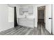 Kitchenette area with gray cabinets, sink, white countertop, and gray wood-style flooring at 10429 Rose Palisade St, Las Vegas, NV 89141