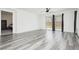 Living room featuring gray wood-style flooring, white walls, and a sliding glass door at 10429 Rose Palisade St, Las Vegas, NV 89141