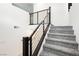 Carpeted staircase with modern horizontal bar railing provides a bright, minimalist design element at 10429 Rose Palisade St, Las Vegas, NV 89141