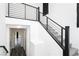 Modern staircase features a metal railing, bright white walls, carpeted steps, and views into other rooms at 10429 Rose Palisade St, Las Vegas, NV 89141