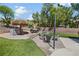 The backyard has a tiki bar, dining area and a fire pit with chairs, perfect for hosting guests at 10645 Redwood Grove Ave, Las Vegas, NV 89144
